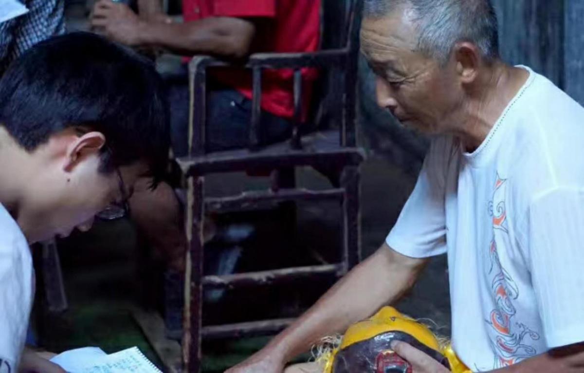 谭钦允（左一）采访乐安傩舞传承人